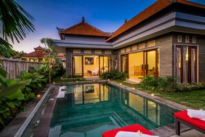 Una casa moderna con piscina, comedor y jardín bien cuidado.