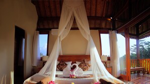 A bed with a canopy, pillows, and a wooden headboard. - Warisan Ubud Villa (Tegallalang)