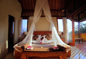 A bed with a canopy, pillows, and a wooden headboard. - Warisan Ubud Villa (Tegallalang)