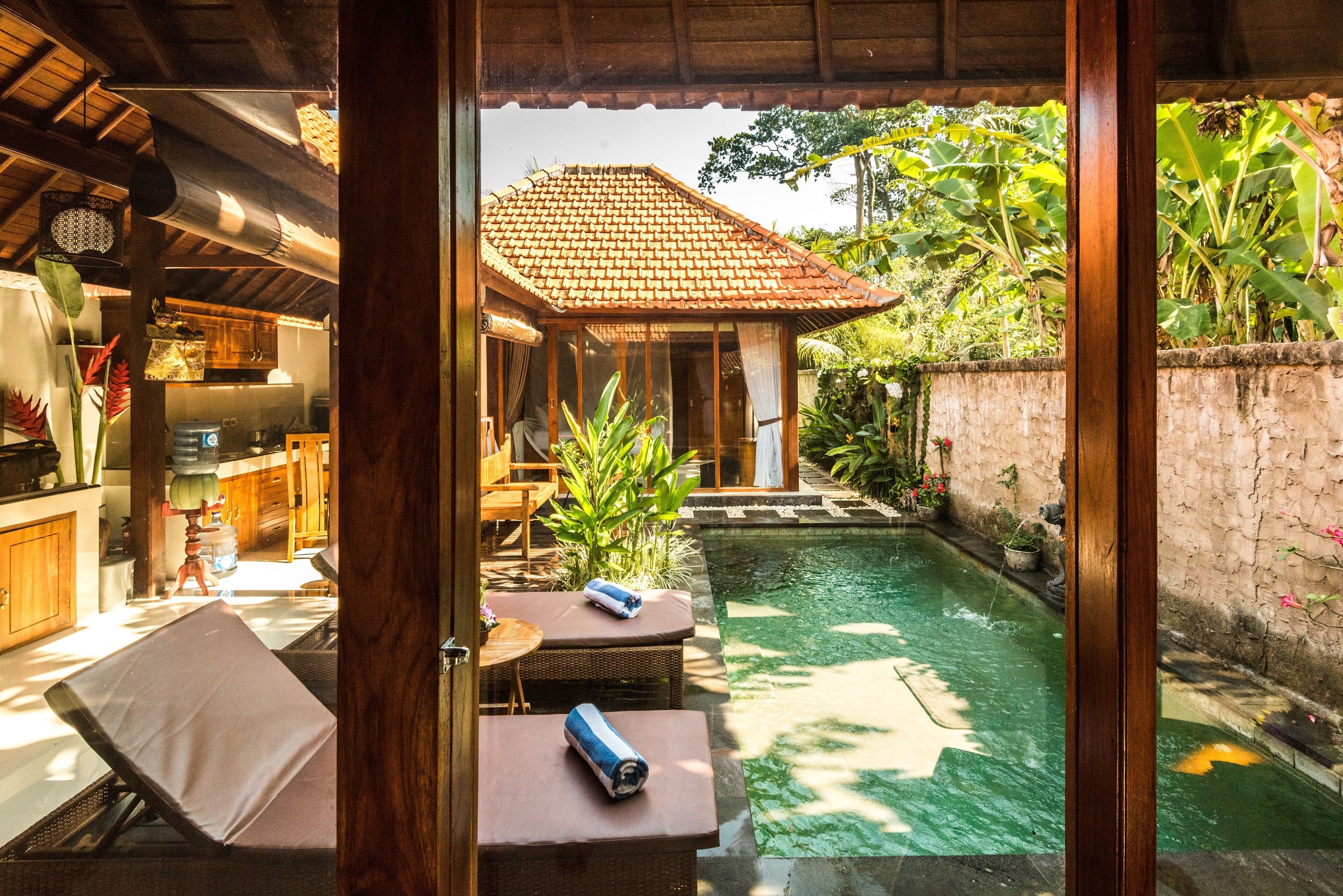 A view of a pool area with lounge chairs and a small garden.