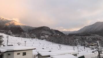 A snowy mountain village with buildings and a ski slope.
