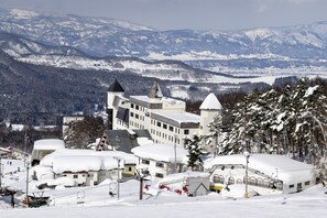 A snow-covered mountain resort with ski lifts, a large building with multiple towers, and a ski slope. - Hotel Tagawa (Yamanouchi)
