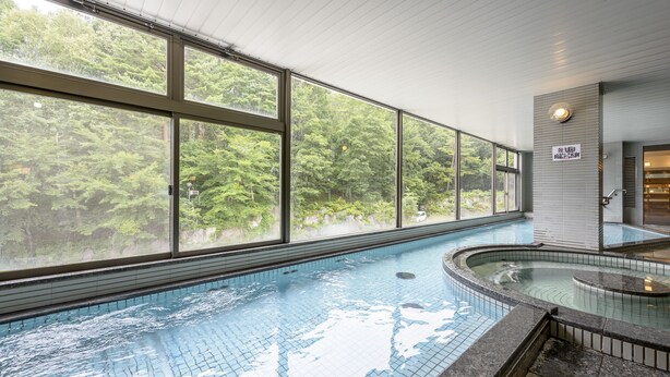 A swimming pool with clear views of a forest through large windows. - Hotel Tagawa (Yamanouchi)