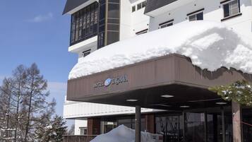 A hotel with a covered entrance and a snow-covered roof.