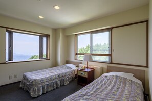 A hotel room with two single beds, a nightstand with a lamp, and large windows offering a view of the outdoors. - Hotel Tagawa (Yamanouchi)
