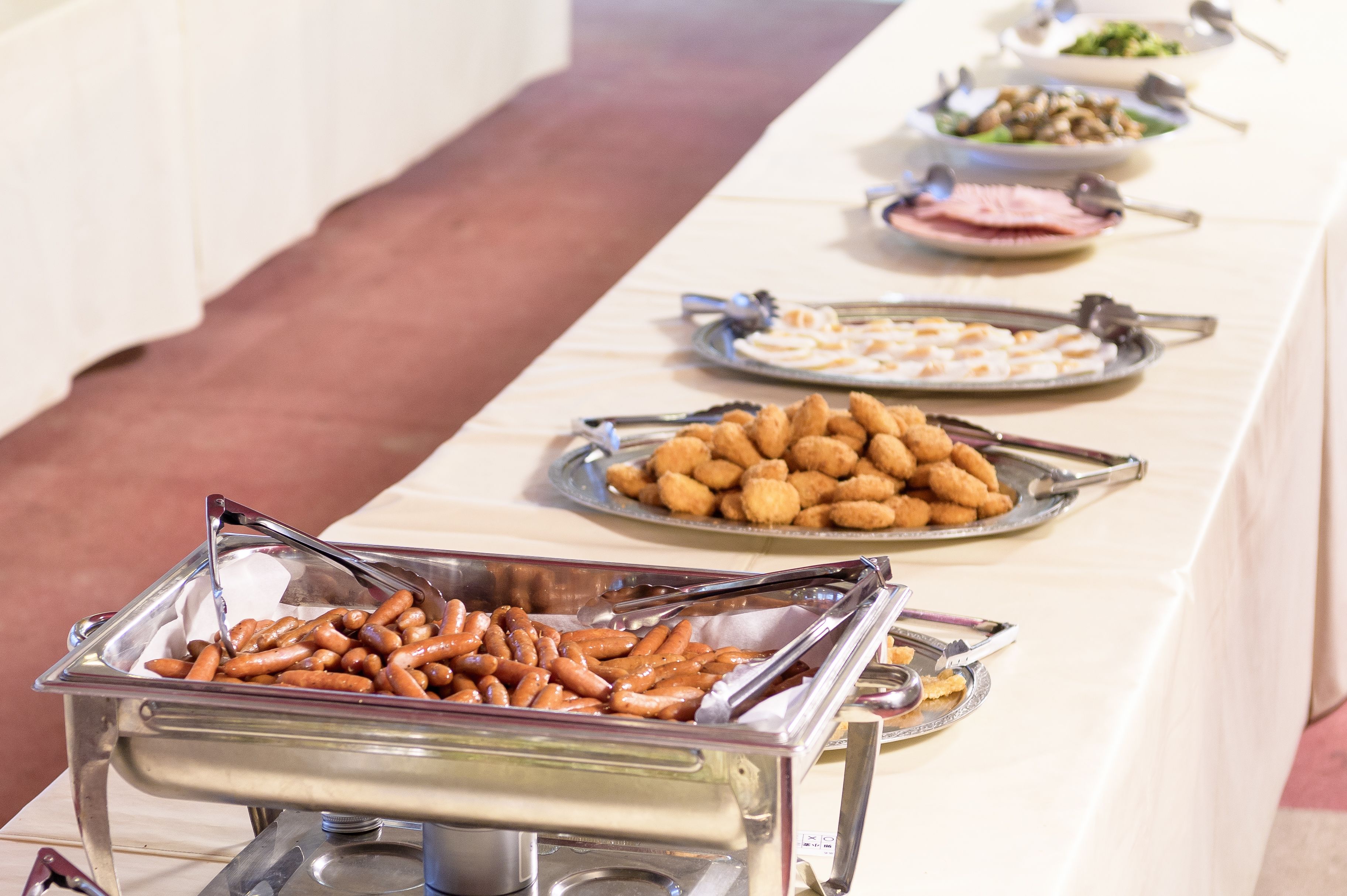 A buffet table with various food items, including pretzels and other snacks.
