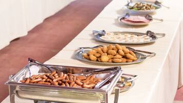 A buffet table with various food items, including pretzels and other snacks.