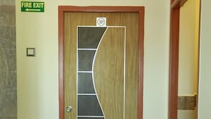 Une porte de sortie d’urgence avec une signalisation indiquant la direction de la sortie.
