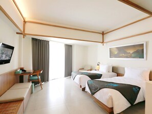 Une chambre d’hôtel avec deux lits, un bureau avec une chaise, une télévision et un tableau au mur.
