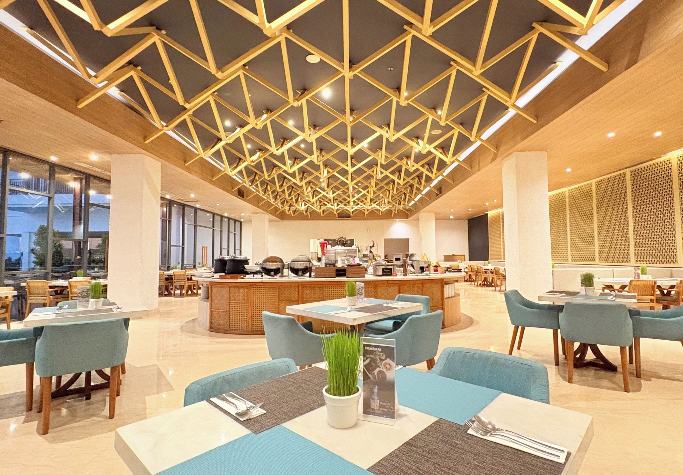 A modern restaurant with a geometric ceiling design, a central bar area, and seating arrangements.