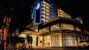 A modern hotel with a multi-story structure, large windows, and a covered entrance.
