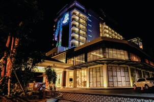 Un hotel moderno con una estructura de varios pisos, amplias ventanas y una entrada cubierta.