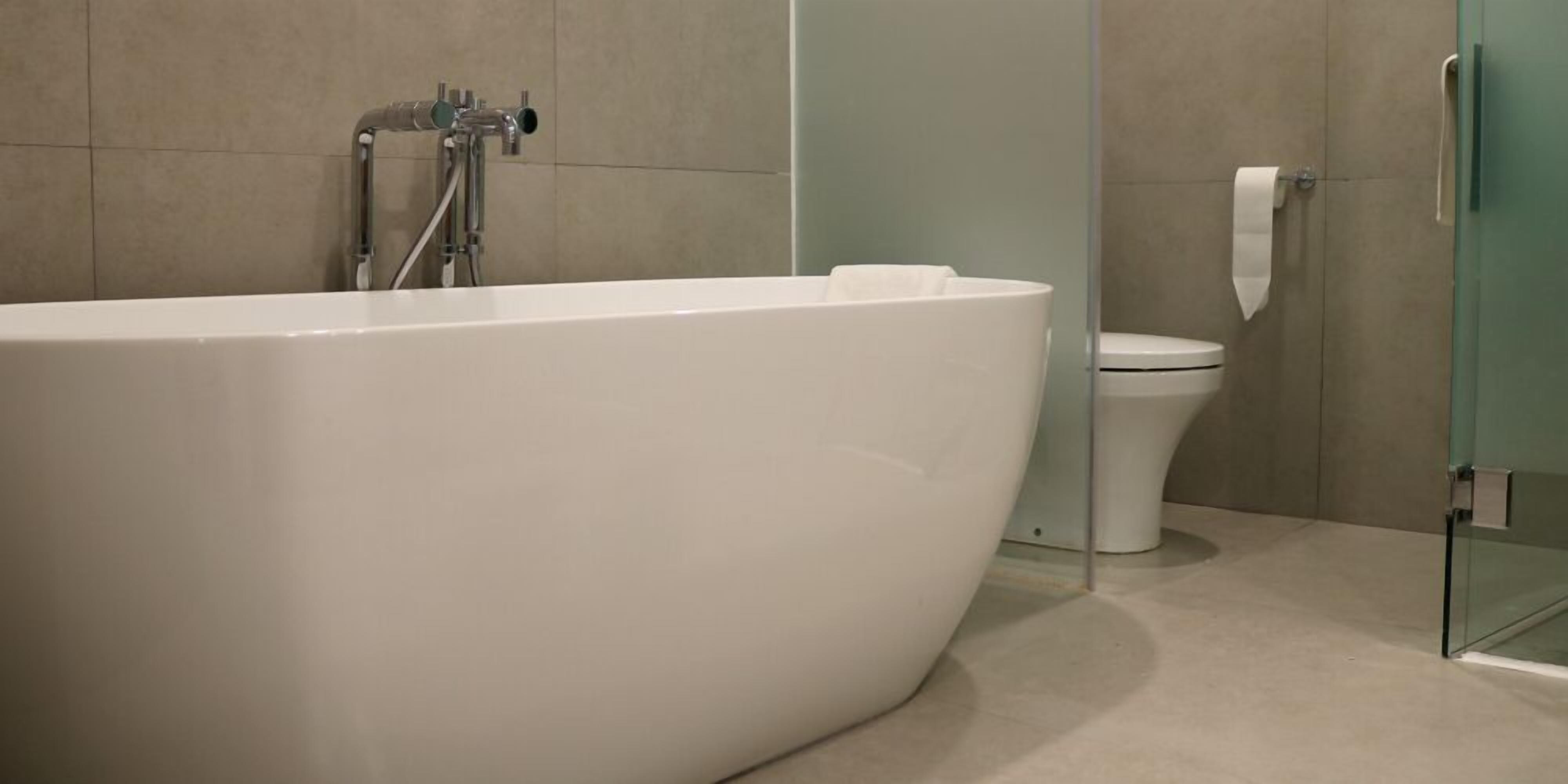 Un baño moderno con una bañera independiente, un inodoro y un box de ducha de vidrio.