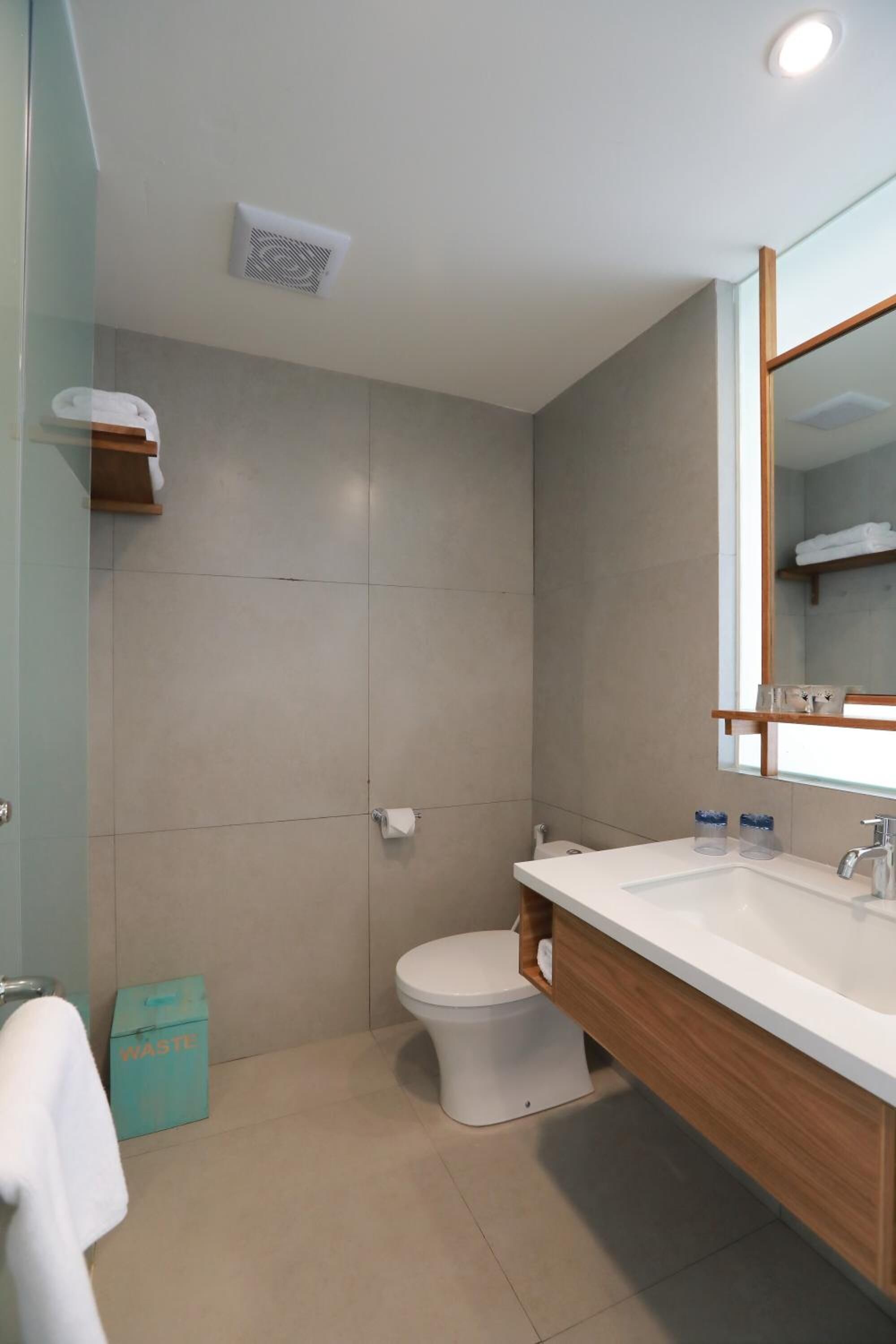 Et moderne badeværelse med toilet, vask og spejl.