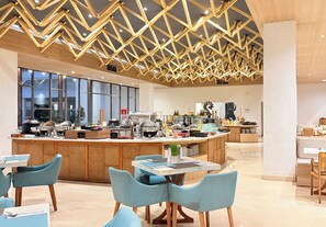 Une cuisine moderne dotée d’un îlot central, d’un coin bar et d’un espace repas.