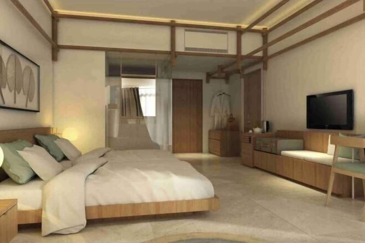 Relax in this serene bedroom with a large bed, nightstand, and dresser, plus a large window with sheer curtains.