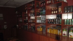 A bar with shelves stocked with various bottles and cans. - Magi Guest House (Thika)