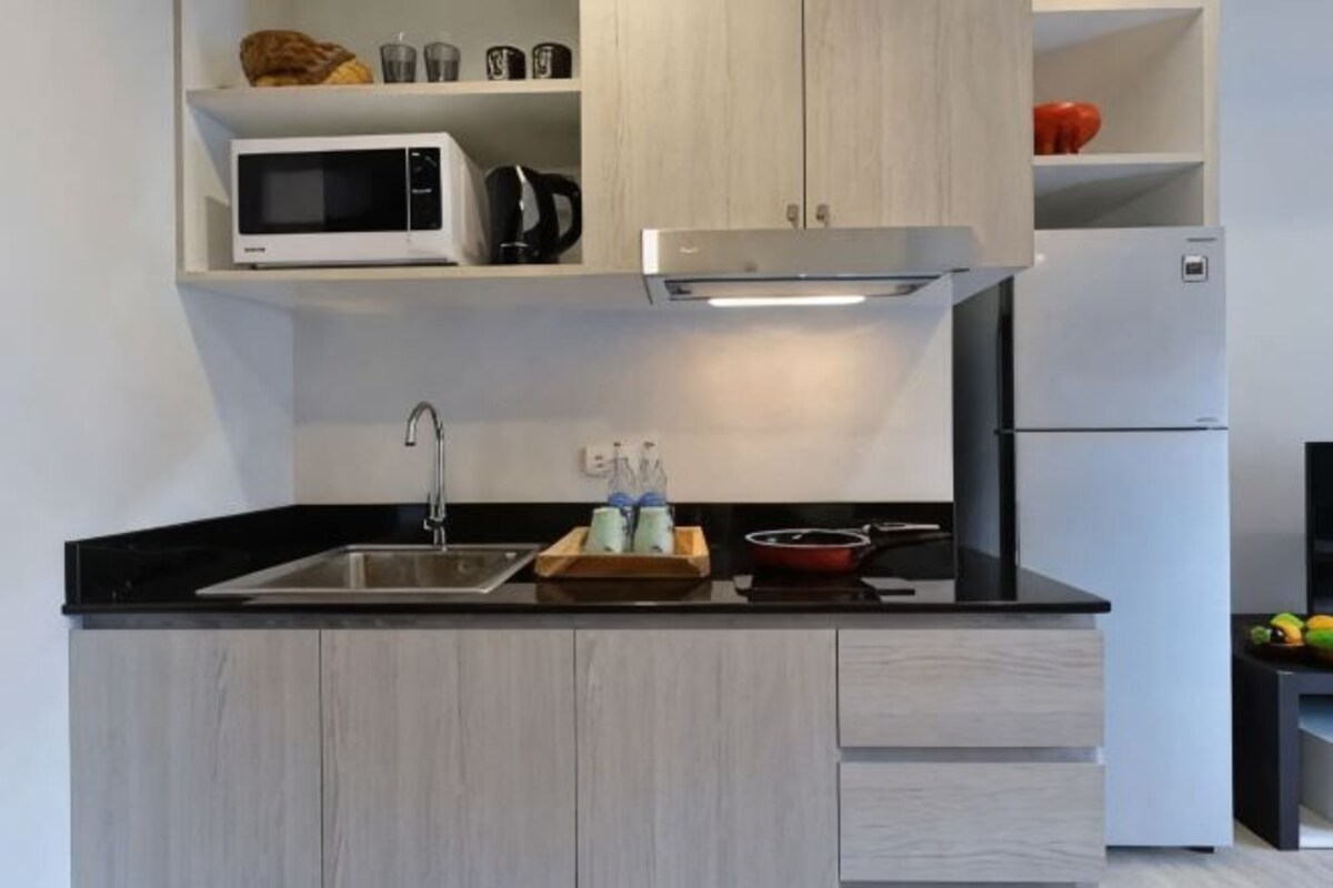 A kitchen with a microwave, sink, and cabinets.
