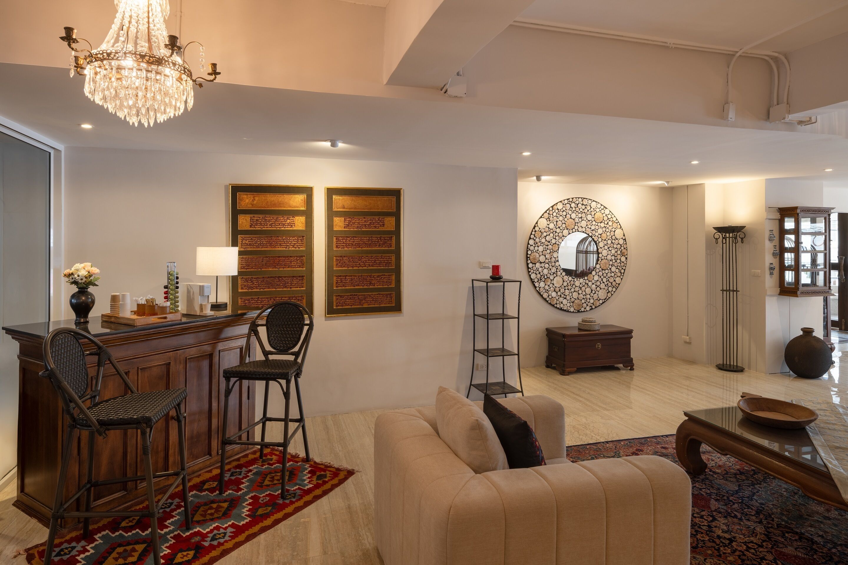 A modern living room with a bar area, a chandelier, and decorative wall art.