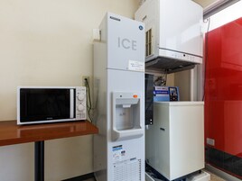 A compact kitchenette with a microwave, an ice dispenser, and a water cooler.