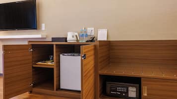 Une chambre d’hôtel compacte équipée d’un réfrigérateur, d’un four à micro-ondes et d’un petit lavabo.