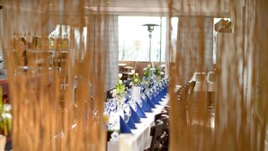 A long table set for a formal event with blue napkins, white flowers, and clear glassware. - Hotel Restaurant Litermont (Nalbach)
