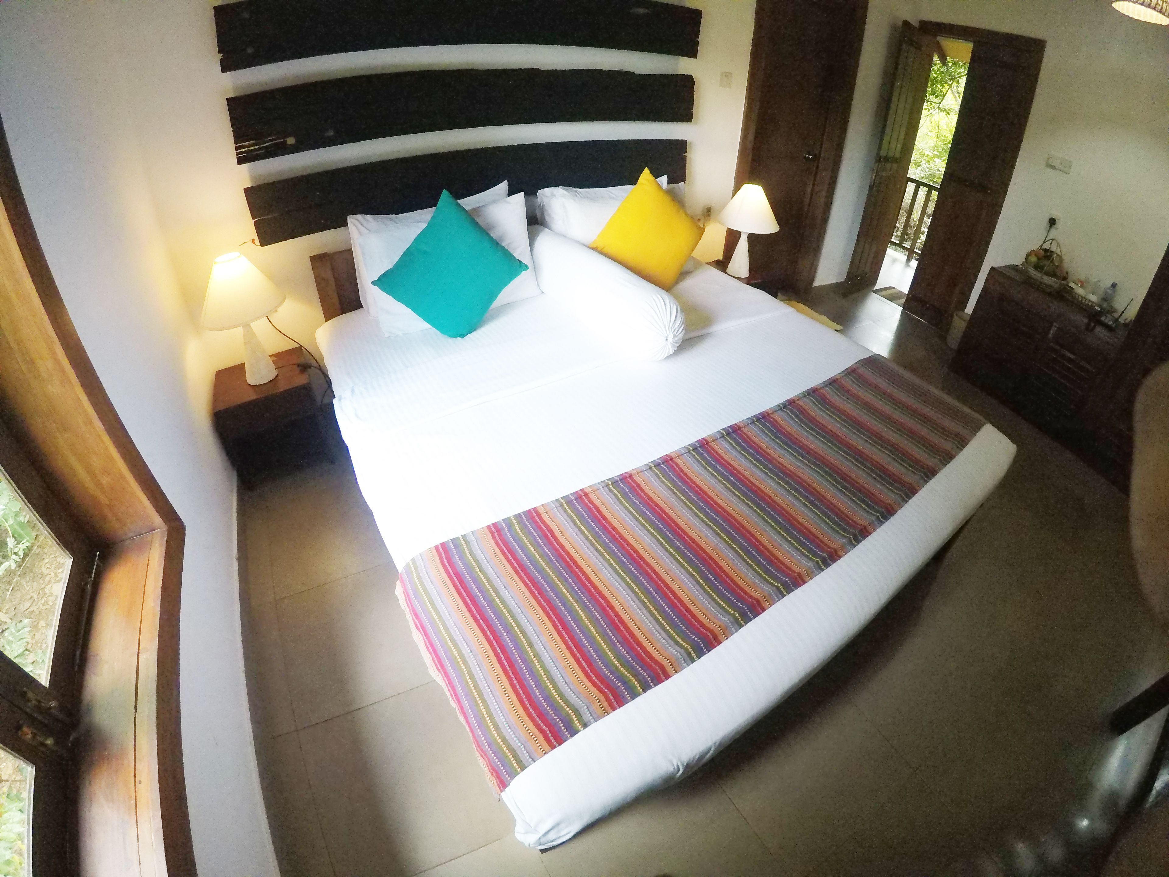 A neatly made bed with a striped bedspread, two bedside lamps, and a headboard with horizontal stripes.