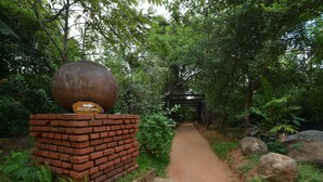 A brick reception area with a large decorative sphere and a reception sign. - Pinthaliya Resort & Spa (Avudangawa)