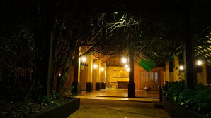 An outdoor entrance with a covered seating area, a pathway leading to a building, and a decorative light installation above. - Pinthaliya Resort & Spa (Avudangawa)