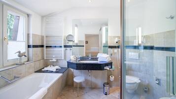 Un baño moderno con bañera, tocador y retrete.