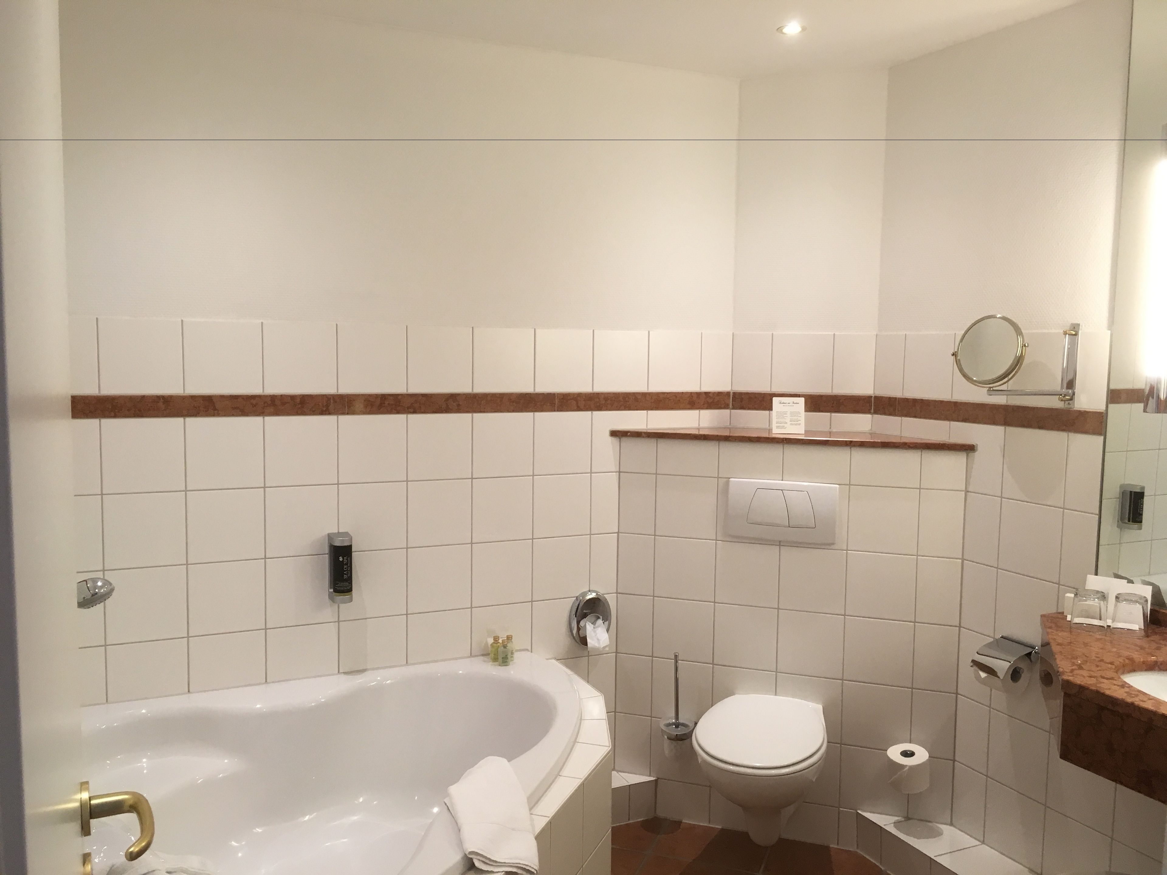 Ein modernes Badezimmer mit Badewanne, Toilette und Waschtisch.