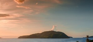 A coastal landscape with a prominent hill and a small island in the distance. - Almali Luxury Residence (Rawai)