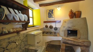 Una cocina compacta con horno empotrado, lavamanos y estufa.