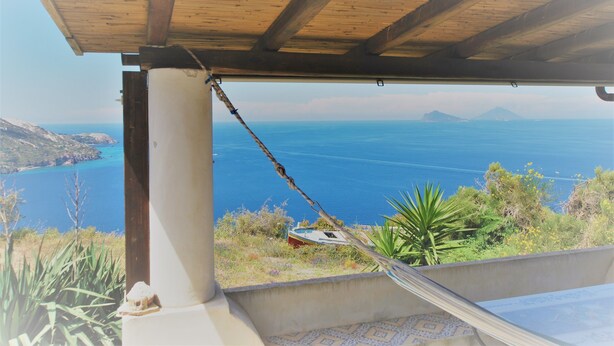 Une structure de plafond en bois offrant une vue sur la mer et les montagnes.