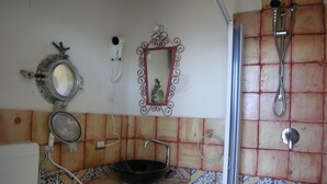 Une salle de bain avec un lavabo, un miroir et une douche.