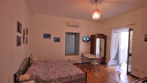 A bedroom with a bed, a desk, and a television. - Pomice Studio (Lipari)