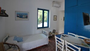 A room with a bed, a table, and a window. - Villino Vulcano (Lipari)