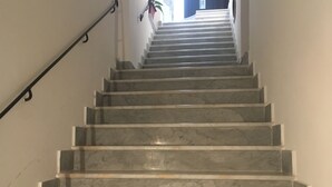 A marble staircase with a handrail on the left, leading up to a landing. - Discesa Delle Capre (Palermo)