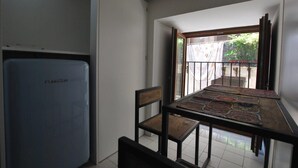 A dining area with a table and chairs, a refrigerator, and a view of a balcony with a railing. - Discesa Delle Capre (Palermo)