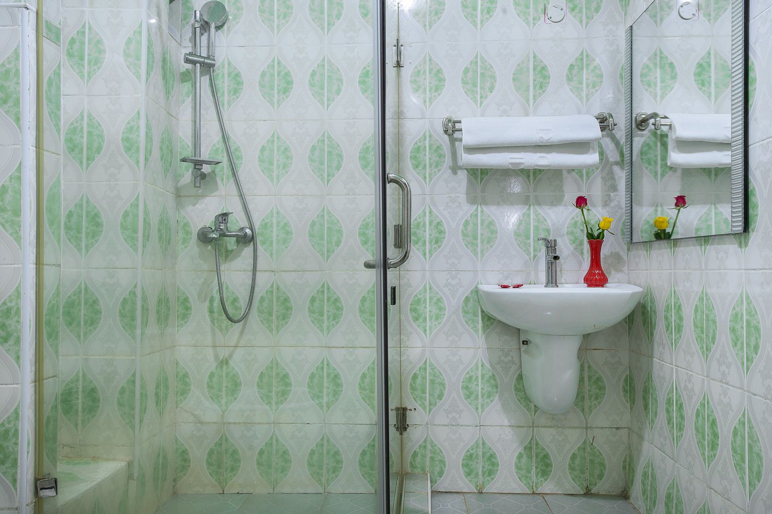 A bathroom with a shower, sink, and mirror.