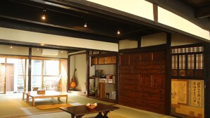 Een traditionele Japanse kamer met tatami vloerbedekking, een lage houten tafel en een gitaar.