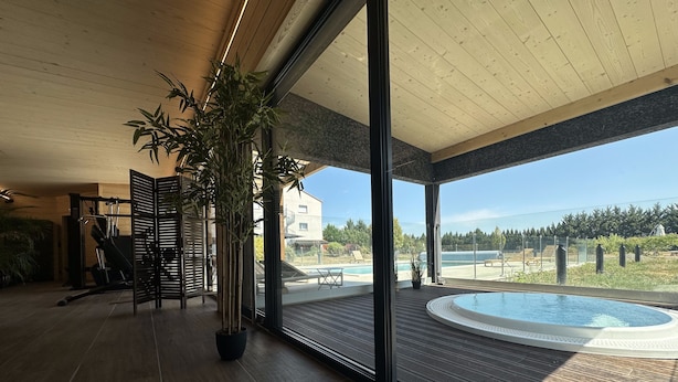 Un área de piscina interior moderna con vistas a un barrio residencial y un cielo despejado.