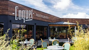 Un restaurante llamado Coquet con terraza y un diseño moderno.
