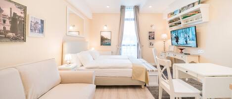 Una habitación de hotel moderna con una cama, un sofá, un escritorio y un televisor.
