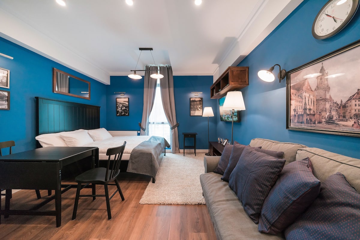 Ein modernes Schlafzimmer mit Bett, Schreibtisch und Sofa.