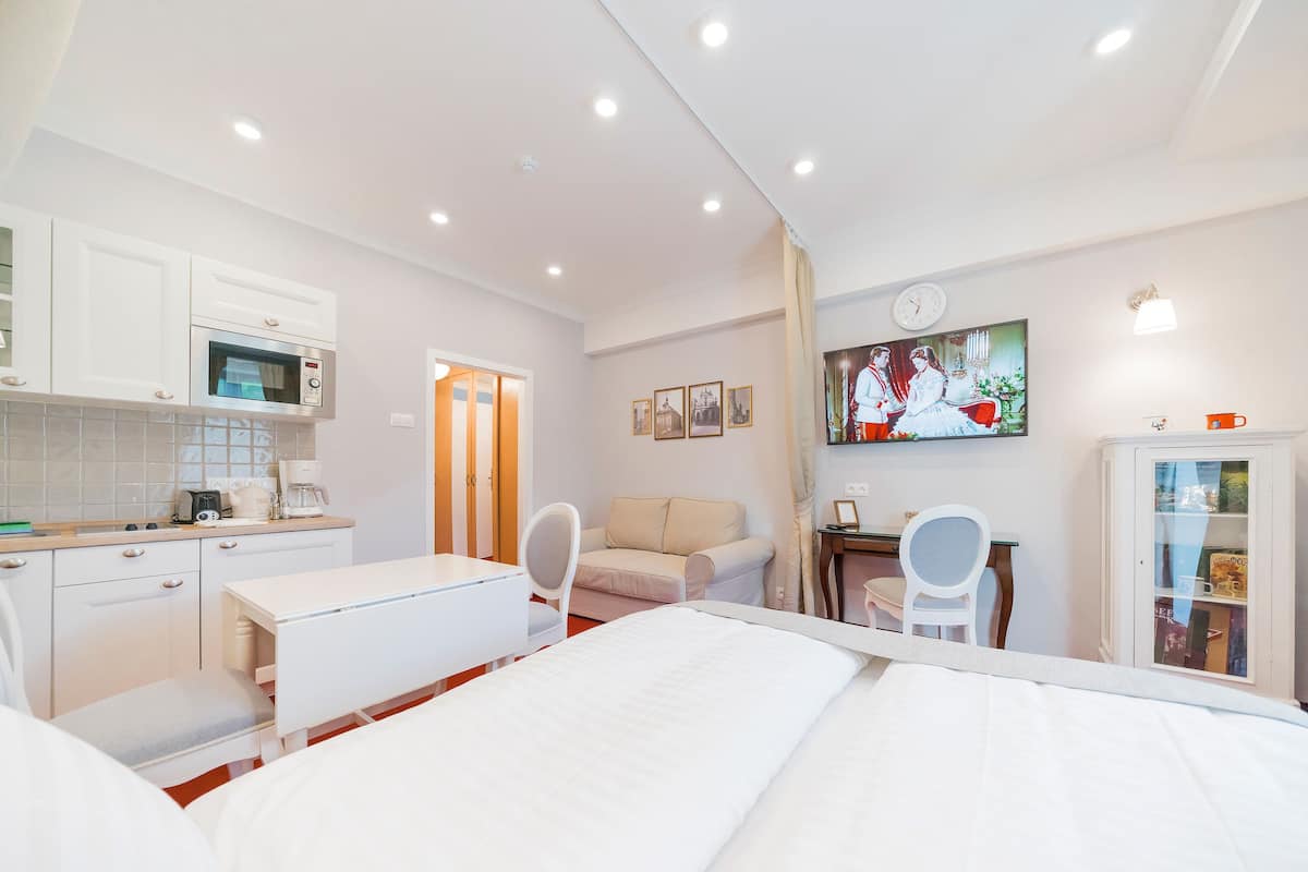 Ein Hotelzimmer mit einem Bett, einem Schreibtisch, einem Sessel, einem Fernseher, einer Mikrowelle und einem Schrank.