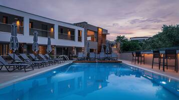 Piscine extérieure, parasols de plage, chaises longues