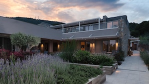 A modern two-story house with a balcony, stone facade, and landscaped garden. - KB Ammos (Skiathos)
