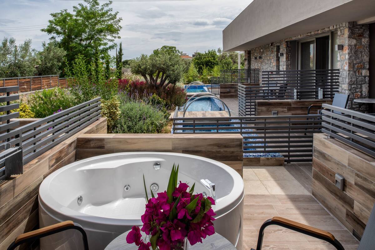 A rooftop terrace with a hot tub, seating area, and a swimming pool.