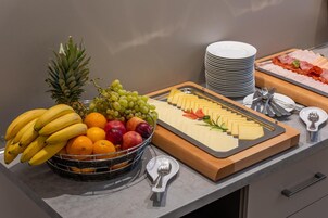 Un tavolo per buffet con frutta, formaggi e salumi.